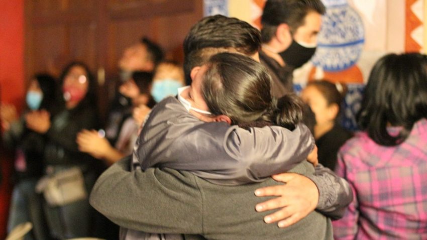 two people hugging each other in front of a crowd of people