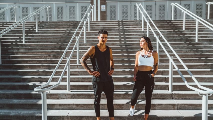woman in black tank top and black pants standing on gray concrete stairs